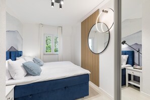 A modern bedroom with a large bed, a bedside table, a mirror, and a window with curtains. - Holiday Apartment With a Private Terrace & Hot Tub, Near the Beach (Split)
