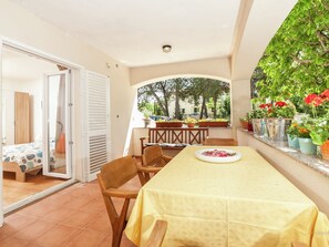 Enjoy meals for two in this inviting dining area with a table set amidst lush greenery and a balcony.
