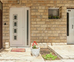 Welcome to a charming entrance with a beautiful garden and a warm, inviting atmosphere.