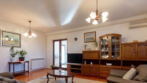 A living room with a sofa, a coffee table, a TV, and a cabinet. - Holiday Home in Zemunik Donji With Private Pool (Zemunik Donji)