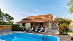 A swimming pool with lounge chairs and a covered patio area. - Holiday Home in Zemunik Donji With Private Pool (Zemunik Donji)