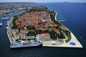 A coastal cityscape with a prominent ferry dock, historic buildings, and a marina. - Modern Newly Built Apartment, Geat Location, Private Parking Space, WiFi (Zadar)