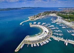 Boats docked in a sheltered marina surrounded by residential buildings and green spaces.