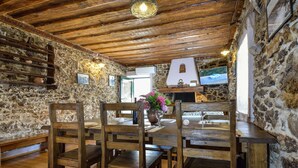 Un comedor rústico con mobiliario de madera y paredes de piedra.