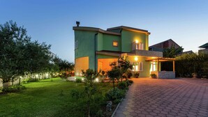 A modern two-story house with a well-maintained garden and a paved driveway. - Luxury Apartment in Zadar With Covered Terrace (Zadar)