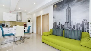 A modern living room with a green sofa and a cityscape mural on the wall. - Luxury Apartment in Zadar With Covered Terrace (Zadar)