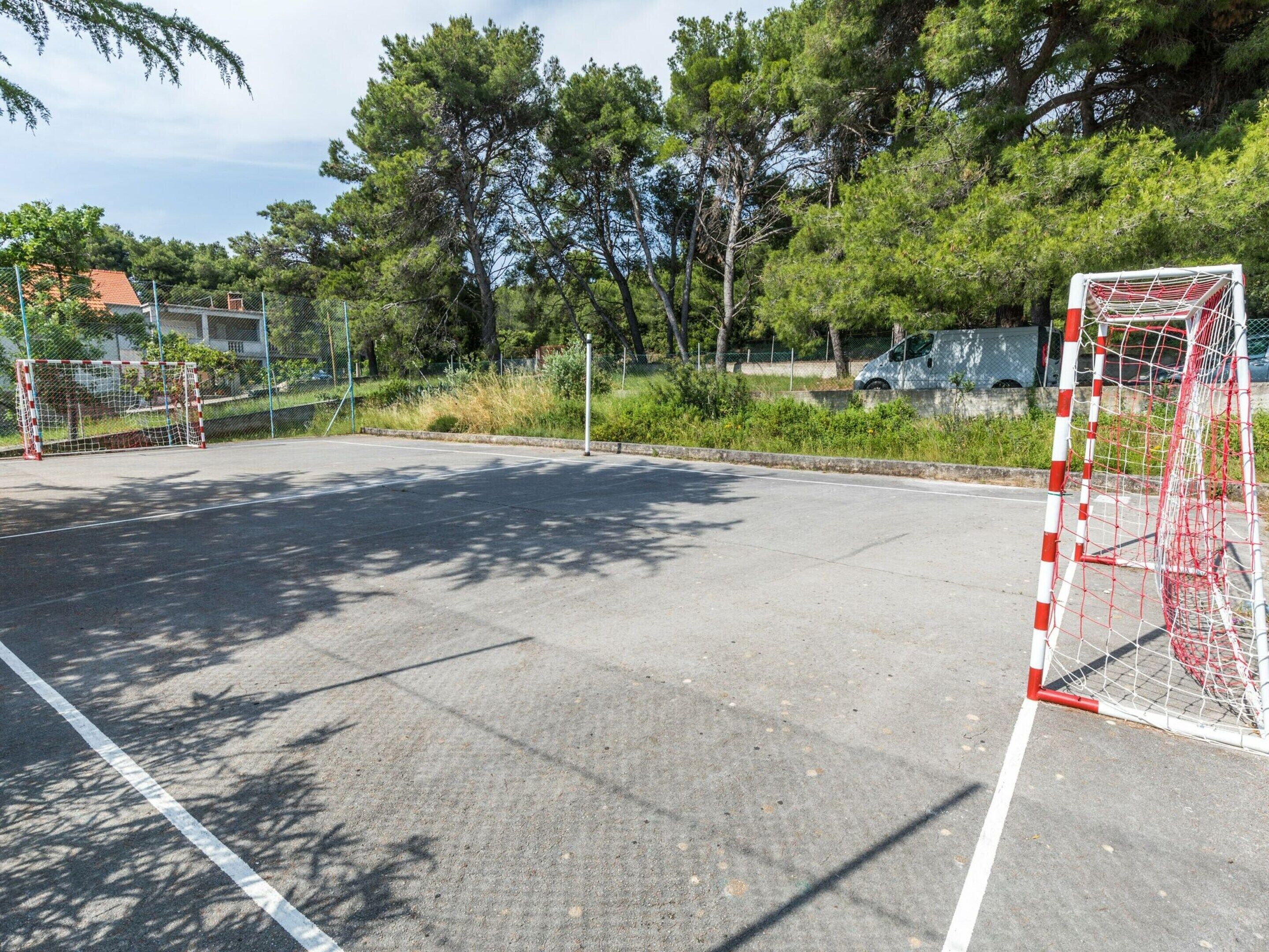 An empty sports field with goalposts and a fence.