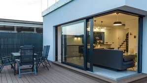 A modern outdoor patio area with a dining set and a sofa, leading to an interior space with a kitchen and living area. - Luxury Villa With Private Pool, Great sea View, Near the Beach (Pakostane)
