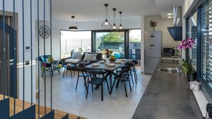 A modern kitchen with a dining area, large windows, and a view of the outdoors. - Luxury Villa With Private Pool, Great sea View, Near the Beach (Pakostane)