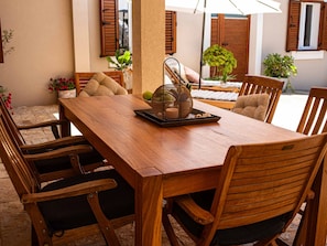 A wooden dining table with chairs, a woven basket with fruits, and a potted plant. - Spacious Holiday Home in Privlaka With Garden (Privlaka)