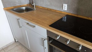 A kitchen with a wooden countertop, stainless steel sink, and a built-in oven. - Modern Holiday Home With Pool (Bibinje)