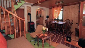 A cozy wooden interior with a dining area, a fireplace, and a staircase. - Holiday Home in Brod na Kupi by River Kupa (Delnice)