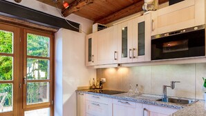 A modern kitchen with light-colored cabinets, a granite countertop, and a stainless steel sink. - Beautiful Villa Consisting of two Houses With Private Pool, Near Pula and Beach (Liznjan)