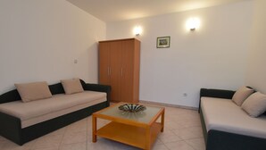 Ein Wohnzimmer mit zwei Sofas, einem Holztisch und einem Kleiderschrank.
