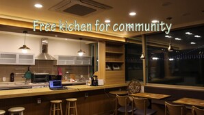 Una cocina moderna con barra, equipada con tostadora, hervidor eléctrico y otros electrodomésticos.