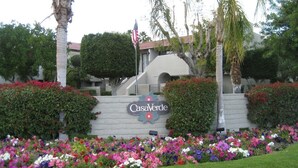 A sign for Casa Verde with a landscaped garden in front.