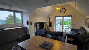 Un espace de vie moderne de style loft comprenant un coin repas, une cuisine et un coin salon.