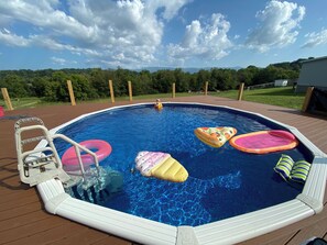 An above-ground swimming pool with inflatable floats, a ladder, and a wooden deck. - Mountain View set on 2+ acres near Greeneville TN (Afton)