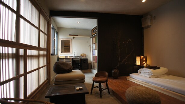 Een traditionele Japanse kamer met tatami vloeren, een lage houten tafel, een kussenbank en een futonbed.