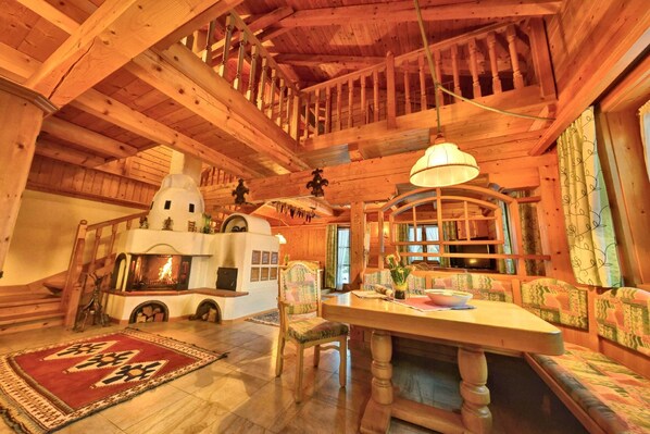 Cozy cabin-style retreat with a central fireplace, wooden staircase, and seating area.