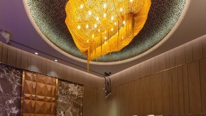 A modern hotel room with a large bed, a shower, and a unique ceiling chandelier. - Royal Group Motel Jhong Hua Branch (Kaohsiung)
