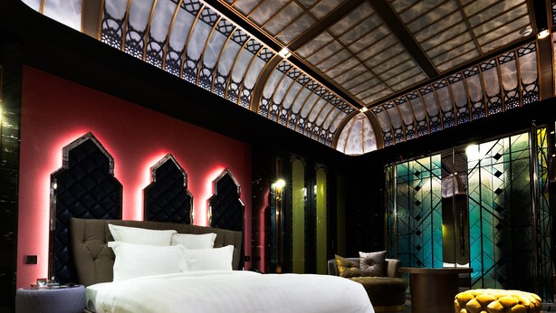 A modern bedroom with a large bed, a seating area, and a glass wall with a view. - Royal Group Motel Jhong Hua Branch (Kaohsiung)