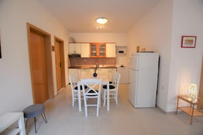 Enjoy cooking in this well-equipped kitchen with a central island, refrigerator, and dining area.
