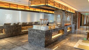 A modern hotel lobby with marble flooring, a central reception desk, and a glass partition. - Wassim Hotel (Shanghai)