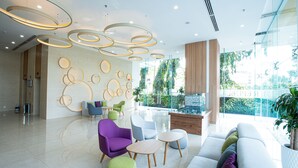 A modern lobby with a seating area, a reception desk, and a large window with a view of greenery. - Republic Plaza Serviced Apartment (Ho Chi Minh City)