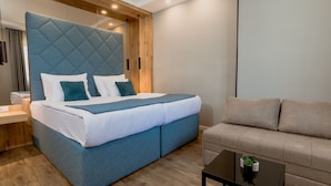 A modern bedroom with a large bed, a sofa, and a small table. - Nobel Gallery Hotel (Belgrade)