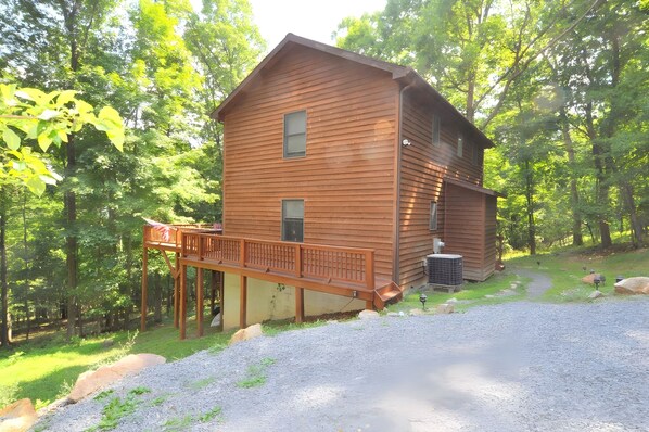 A two-story wooden cabin with a deck, surrounded by trees. - Almost Heaven - Cozy and Wonderful (Berkeley Springs)