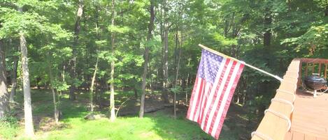 A wooden deck with a flagpole displaying an American flag.