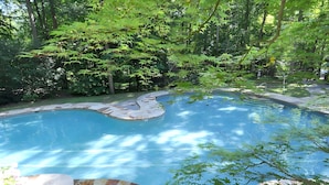 A swimming pool surrounded by lush greenery and trees. - Almost Heaven - Cozy and Wonderful (Berkeley Springs)