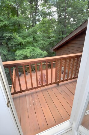 A wooden deck with a railing, surrounded by lush greenery. - Almost Heaven - Cozy and Wonderful (Berkeley Springs)