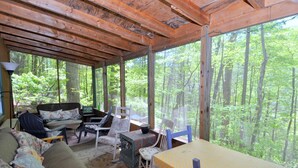 Un chalet rustique avec un plafond en bois, un canapé, une table et des chaises.