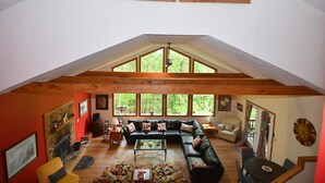 Un loft spacieux avec de hauts plafonds, de grandes fenêtres, une cheminée et un coin salon confortable.