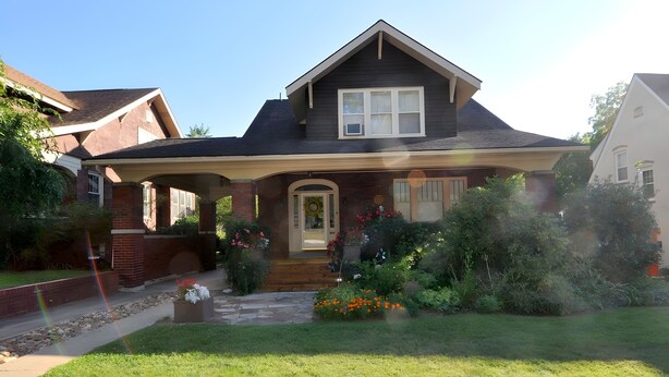 A two-story house with a front porch, a brick foundation, and a well-maintained lawn. - Aunt Beas Bungalow - Right in Town! (Berkeley Springs)