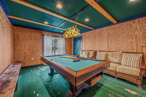 A pool table in a room with wooden walls and a green floor. - Whispering Hills - Couples Getaway (Berkeley Springs)