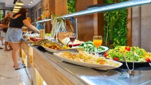 Een buffet met diverse gerechten en een drankje.