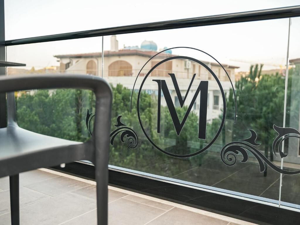 A balcony with a view of a building and greenery.
