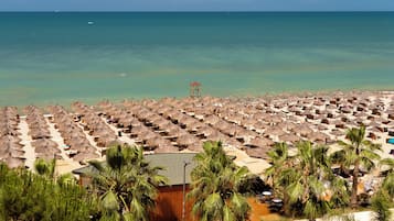 Playa privada, arena blanca, sillas reclinables de playa, sombrillas