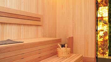 A wooden sauna with benches and a wooden bucket with a ladle.