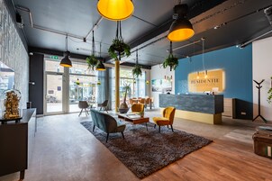 Un área de recepción moderna con pared azul, mostrador de recepción y disposición de asientos.