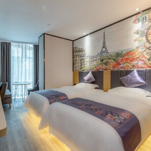 Una habitación de hotel con una cama grande, un escritorio y una silla. Hay un cuadro de la Torre Eiffel en la pared.