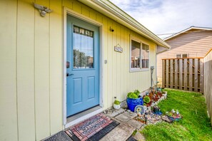 Welcome to this charming home, featuring a cozy entrance with a blue door and a potted plant.