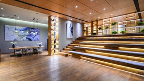 A modern interior with a wooden staircase, a dining area, and bookshelves. - Himalaya Serviced Residences Nankai Tianjin (Tianjin)