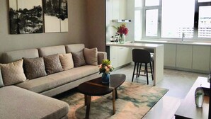 A modern living room with a sofa, coffee table, and artwork on the wall. - Himalaya Serviced Residences Nankai Tianjin (Tianjin)