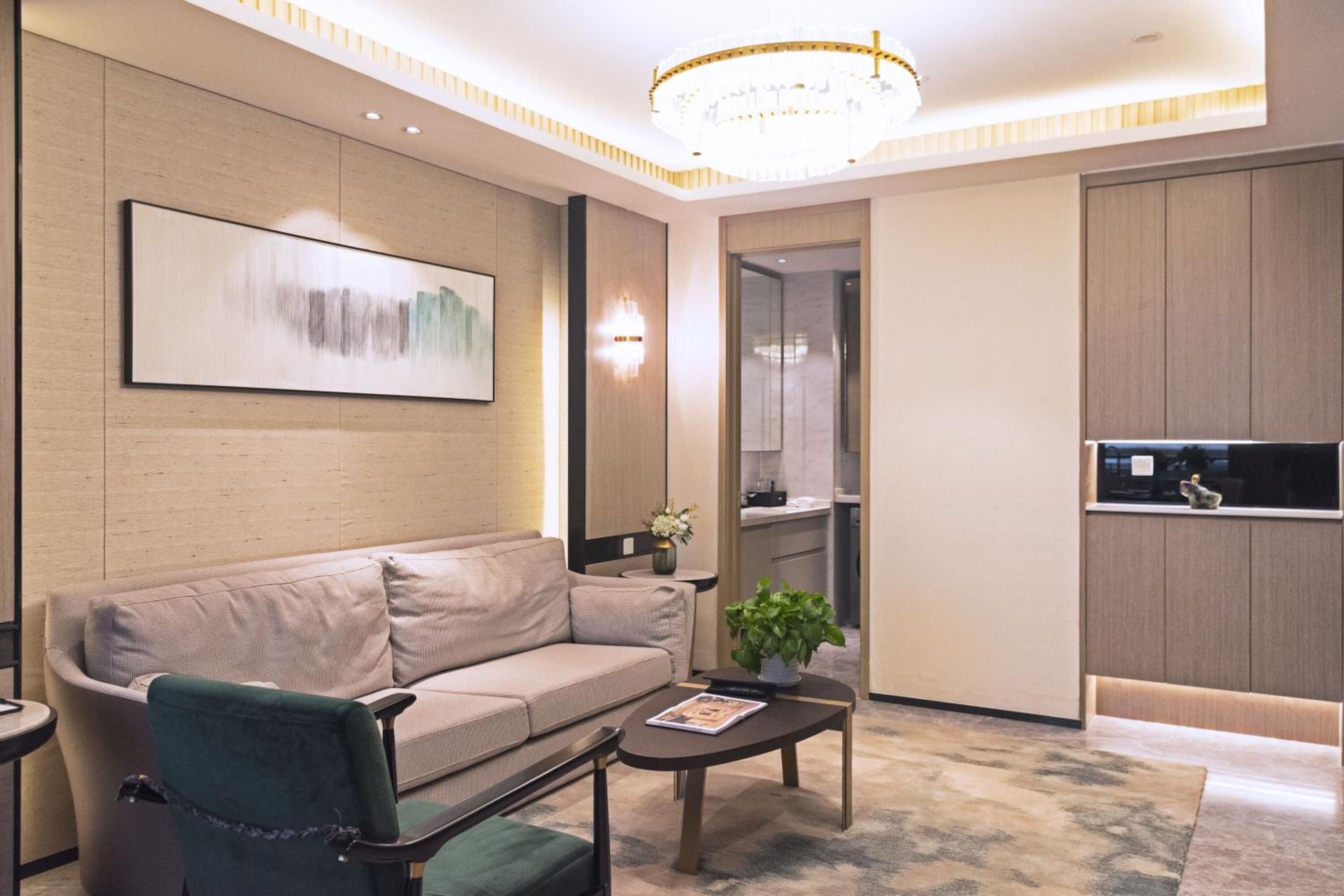 A modern living room with a sofa, coffee table, and a chandelier.