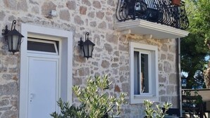 A stone building with a balcony, a door, and two windows. - Boutique Villa Marijini Dvori (Tribunj)