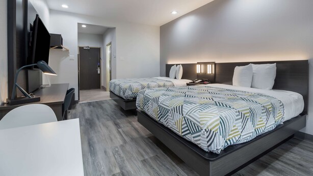 Una habitación de hotel moderna con dos camas, un escritorio y una silla.